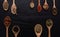 Various kind of dried leaves ,herbs, fruit and flower put in many kind of wooden spoons on black background.