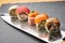 Various kinds of sushi roll set served on a knife blade. Japanese food