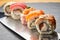 Various kinds of sushi roll set served on a knife blade. Japanese food