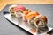 Various kinds of sushi roll set served on a knife blade. Japanese food