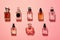 Various luxury perfume bottles on a pink background, top view. ai generative