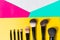 Various make-up brushes in bright yellow, pink, green background, close-up, cosmetics