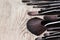 Various makeup brushes on shabby wooden surface