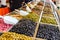 Various marinated olives for sale in a market window.