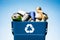 various metal cans in trash bin with recycle sign