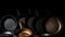 Various non-stick frying pans with handles in a row, chrome-plated, dark background. AI generated.