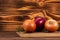 Various onions and rosemary twigs on a cutting board on wooden background. Healthy organic food