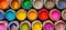 Various open paint cans displayed on a vivid and vibrant multicolored background