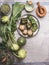 Various organic green vegetables ready for cooking on rustic kitchen table background. Top view. Healthy vegetarian food. Garden