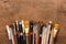 Various paintbrushes collection on brown wooden table