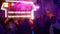 Various people partying and clubbing in a nightclub with many vivid colorful lights - Blurry background
