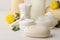 Various personal care products. Soap close-up, cotton pads and sticks and yellow flowers on a white background