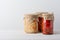 Various pickled fermented cultured vegetables in a glass jar for canning on a white table stand angle