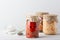 Various pickled fermented cultured vegetables in a glass jar for canning on a white table whith bay leaf, black pepper, coriander