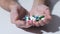 Various pills falling into hands of person, pharmaceutical industry, medication
