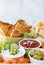 Various popular appetizer dips with crisp bread and vegetables for dipping.