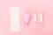 Various sanitary products on pastel pink background