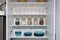 Various seeds in storage jars in pantry, white modern kitchen in background. Smart kitchen organization