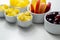 Various set fruits, pineapple, apple, grapes with matured cheddar cheese in bowls