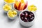 Various set fruits, pineapple, apple, grapes with matured cheddar cheese in bowls