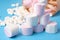 various shapes of marshmallows wrapped in paper on a blue background,