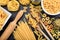 Various shapes of raw pasta on black background