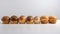 Various small fresh buns with a sprinkle of seeds in a row, white background isolate. AI generated.