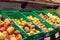 Various sorts of unpacked apples in green plastic box on display in organic super market