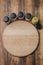 Various spices, round cutting board and cooking utensils on wooden table. Top view