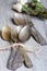 Various spoons and forks entwined on rustic wooden table