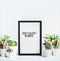 Various succulent plants and cactus in pots around letter board on modern desktop background. Succulent house indoor plants