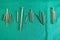 Various surgical titanium screws lie spread out on a green surgical drape