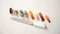 Various sushi rolls with Japanese knife on white stone slate background