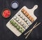Various sushi sets, dill, salmon, crab on a white cutting board Asian food on wooden rustic background top view close up