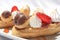 Various sweet tartlet with fruits and profiteroles