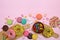 Various sweets - donuts, macaroons, lollipops on a pink background, top view.