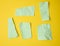 Various torn green pieces of paper on yellow background