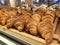 Various types of breads are displayed for sale inside the bakery display rack.