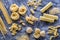 Various types of pasta on the dark flour dusted background