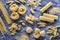 Various types of pasta on the dark flour dusted background