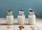 Various types of plant-based lactose-free milk in glass bottles on a blue background, horizontally