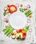 Various vegetables and seasoning cooking ingredients around blank plate on light rustic wooden background, top view composing