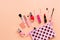 Various women`s makeup cosmetics on a soft pink background. Cosmetic bag, blusher, mascara, lipstick, nail polish and brushes. To