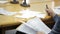 Varnished wooden table with documents and microphones, hand with pencil.