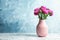 Vase with beautiful aster flower bouquet on table against color background