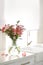 Vase with beautiful flowers on kitchen counter. Stylish element of interior design