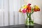 Vase with bouquet of spring freesia flowers on table in room