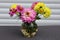 Vase with dahlias and cosmos stands on the table