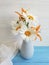 Vase daisy, lily on a wooden background