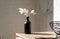 Vase with dried flowers on a neutral background casting shadows on the wall. Dry pampas grass, reed in stylish vase